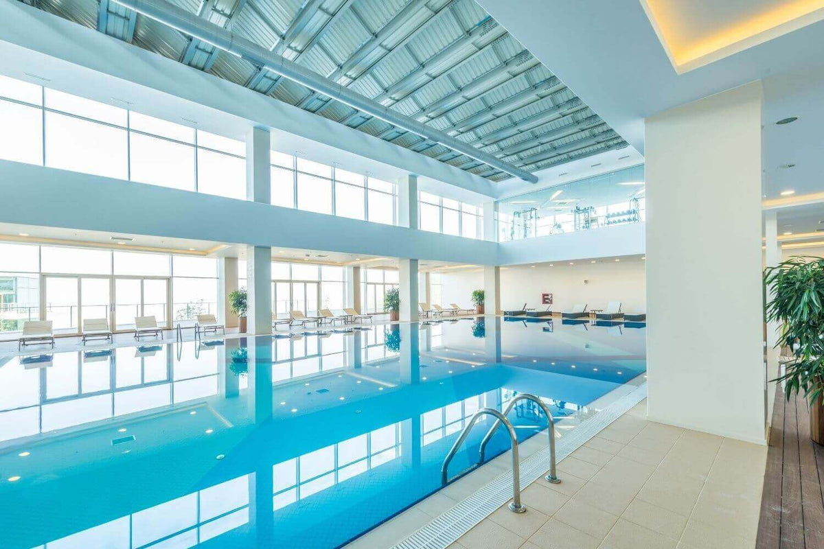Heller Indoor Pool mit großen Fenstern und moderner Beleuchtung, ideal für optimale Lichtverhältnisse.