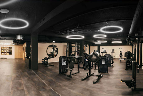Fitnessraum mit moderner Beleuchtung und gut ausgestatteten Geräten für optimale Trainingserlebnisse.
