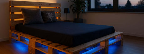 Schwebendes Palettenbett mit LED-Beleuchtung in einem modernen Schlafzimmer mit Pflanzen und Nachttisch.