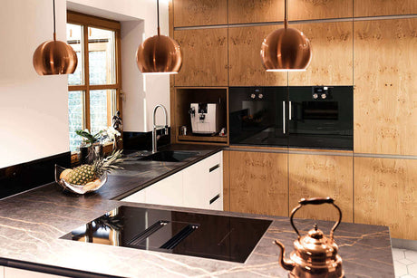 Moderne Küche mit schattenfreier Beleuchtung, eleganten Kupferlampen und stylishen Materialien.