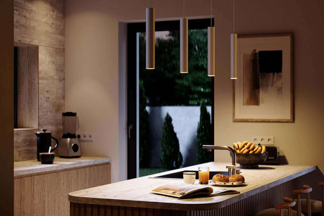 Moderne, weiße Pendelleuchten in eleganter Küche mit Blick auf den Garten und einem stilvollen Esstisch.