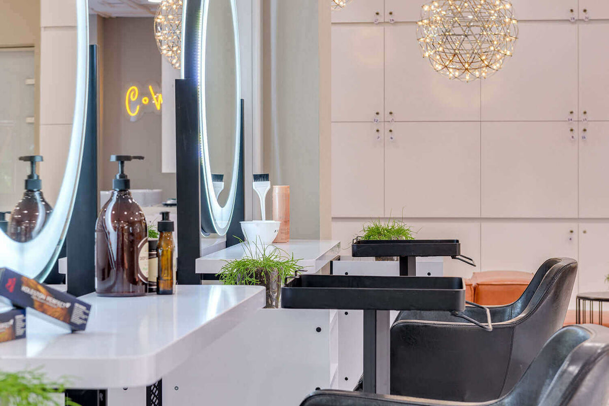 Moderne Friseursalonbeleuchtung mit eleganten Spiegeln und stilvollen Stühlen für optimale Haarpflege.