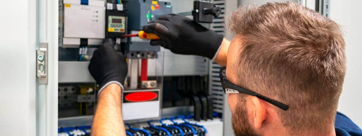Techniker bei der Fehlersuche in einem elektrischen Verteilerkasten mit den richtigen Werkzeugen.