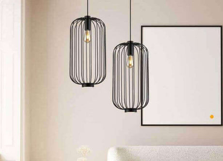 Schwarze Pendelleuchten in modernen Gitterdesigns über einem hellen Möbelstück in einem stilvollen Raum.