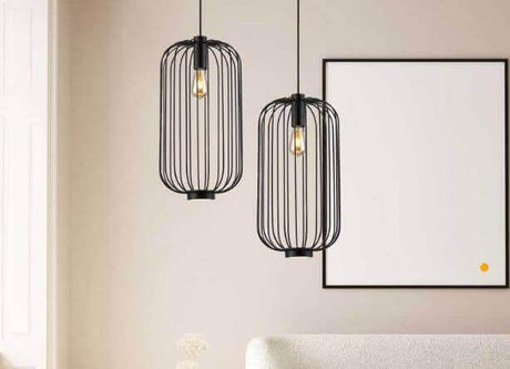 Schwarze Pendelleuchten im modernen Design über einem hellen Sofa in einem stilvollen Wohnraum.
