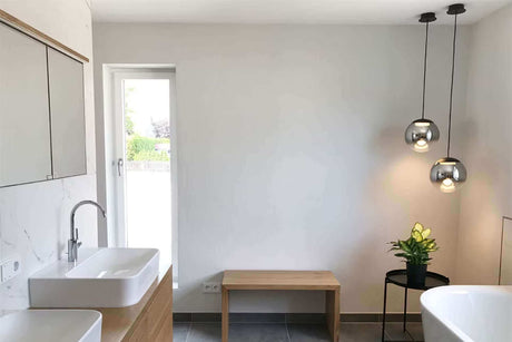 Helles und modernes Gäste-WC mit stilvollen Pendelleuchten und minimalistischer Einrichtung.