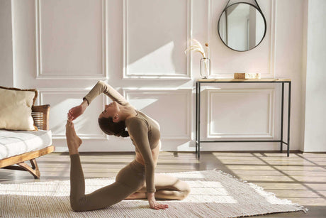 Frau macht eine Yoga-Pose im hellen Yogaraum mit natürlichem Licht und sanften Farben.