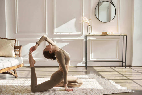 Frau in Yogastellung im hellen Raum mit natürlichem Licht und dekorativem Interieur.