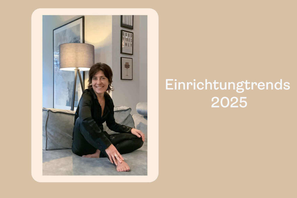 Frau sitzt auf Sofa und bespricht Einrichtungstrends 2025 in modernem Wohnzimmer.