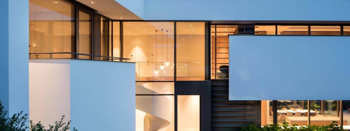 Moderne Treppenhausbeleuchtung in einem eleganten, minimalistischen Haus mit großen Fenstern.
