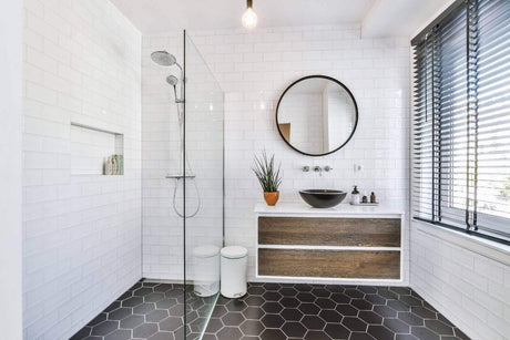Helles modernes Badezimmer mit Dusche, Waschbecken und großen Fenstern für Tageslicht.