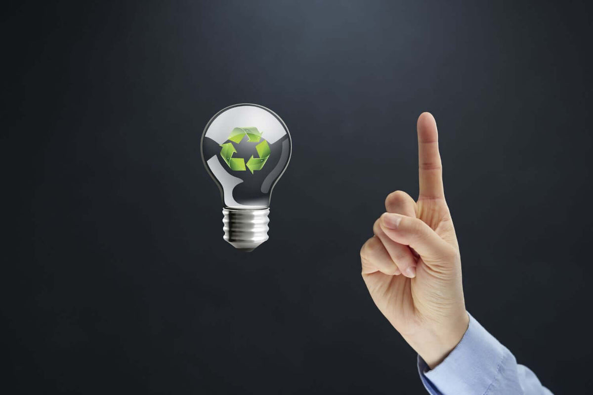 Händ mit Zeigefinger zeigt auf eine Glühbirne mit Recycling-Symbol, Hinweis zur nachhaltigen Entsorgung von Leuchtmitteln.