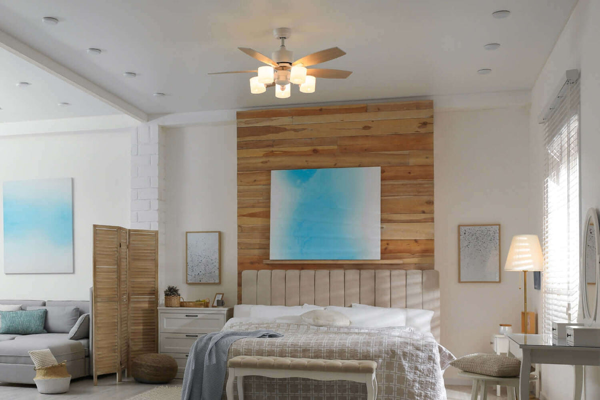 Beleuchteter Deckenventilator in modernem Schlafzimmer mit Holzakzenten und farbigen Wandbildern.