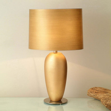 Bordlampe Omega Oval Grande keramikk-metall bladforgylt med gyllen lampeskjerm og oval form.