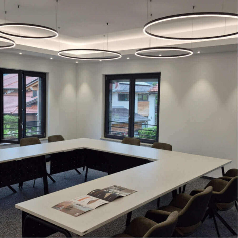 Moderne Konferenzraum mit ovalen Lampen und großen Fenstern, ideal für Besprechungen und Präsentationen.