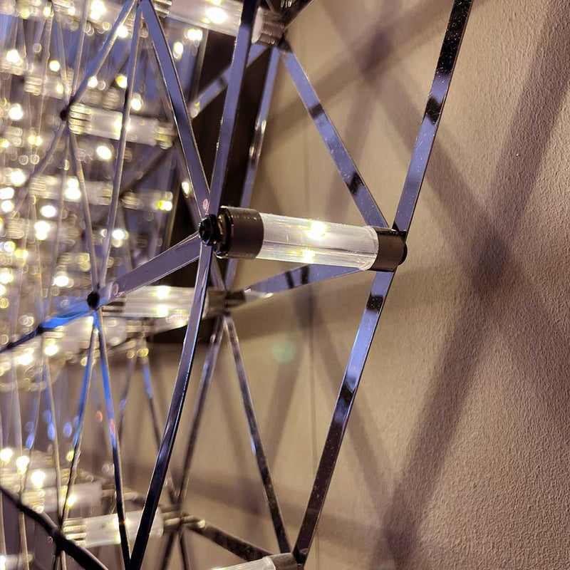 Detailaufnahme einer modernen Lichtinstallation an der Wand, mit funkelnden Lichtern in geometrischer Anordnung.