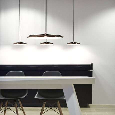 Artist 25 LED Pendelleuchte Kupfer in modernem Interieur über einem Tisch.