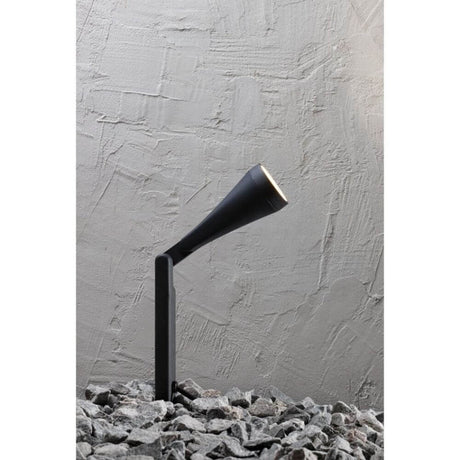 Lampada da terra da esterno Mono nera su superficie di ghiaia, lampada da esterno minimalista con testa regolabile.
