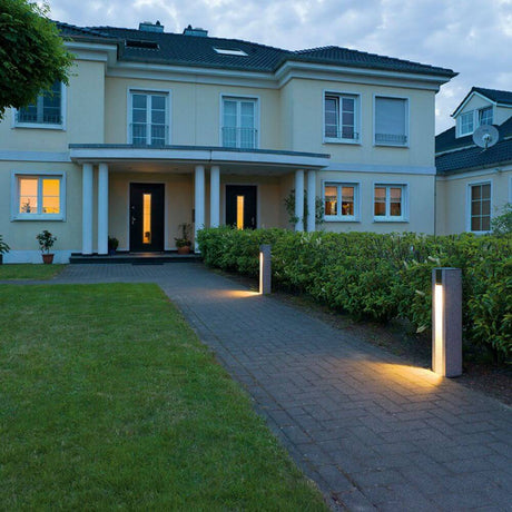 Arrock Slot GU10 Firkantet gulvlampe i granit Salt & Pepper i udendørsområdet foran et moderne hus.