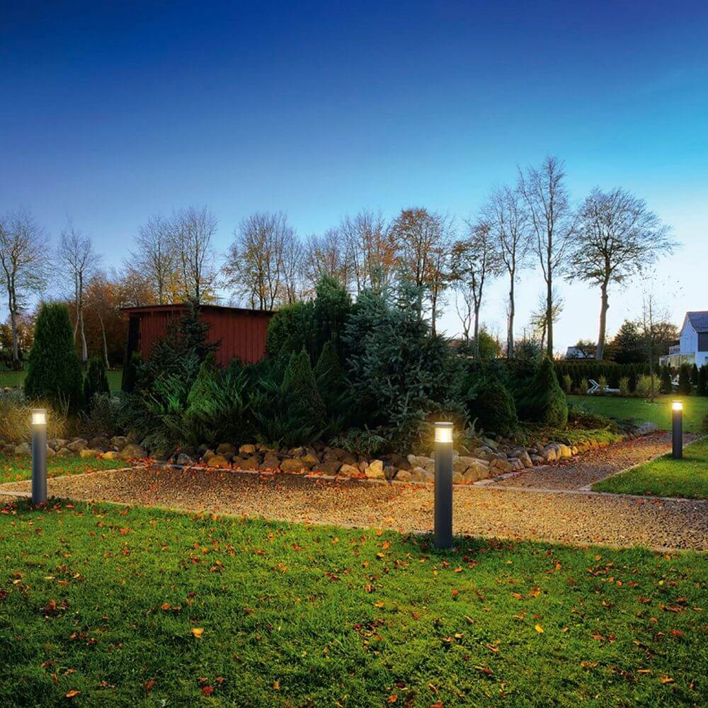 Moderne anthrazitfarbene F-POL Stehleuchte im Außenbereich, blendfreies Licht in Gartenlandschaft.