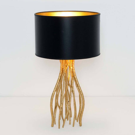 Lampada da tavolo Capri piccola in metallo oro-nero con paralume nero e piedini dorati.