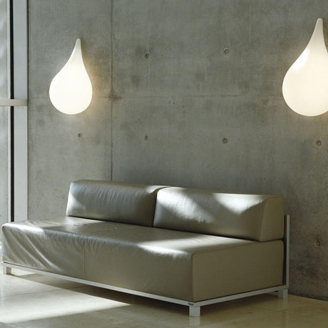 Applique Drop-3S 47 cm Liquid-Light bianca su una parete elegante sopra un moderno divano.