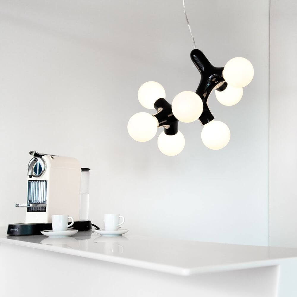 DNA Triple-7 Pendelleuchte Schwarz in modernem Interieur über einer Theke mit Kaffeemaschine.