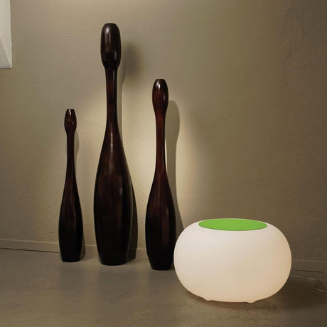 Moree table or stool Bubble next to decorative wooden figures in a modern interior.