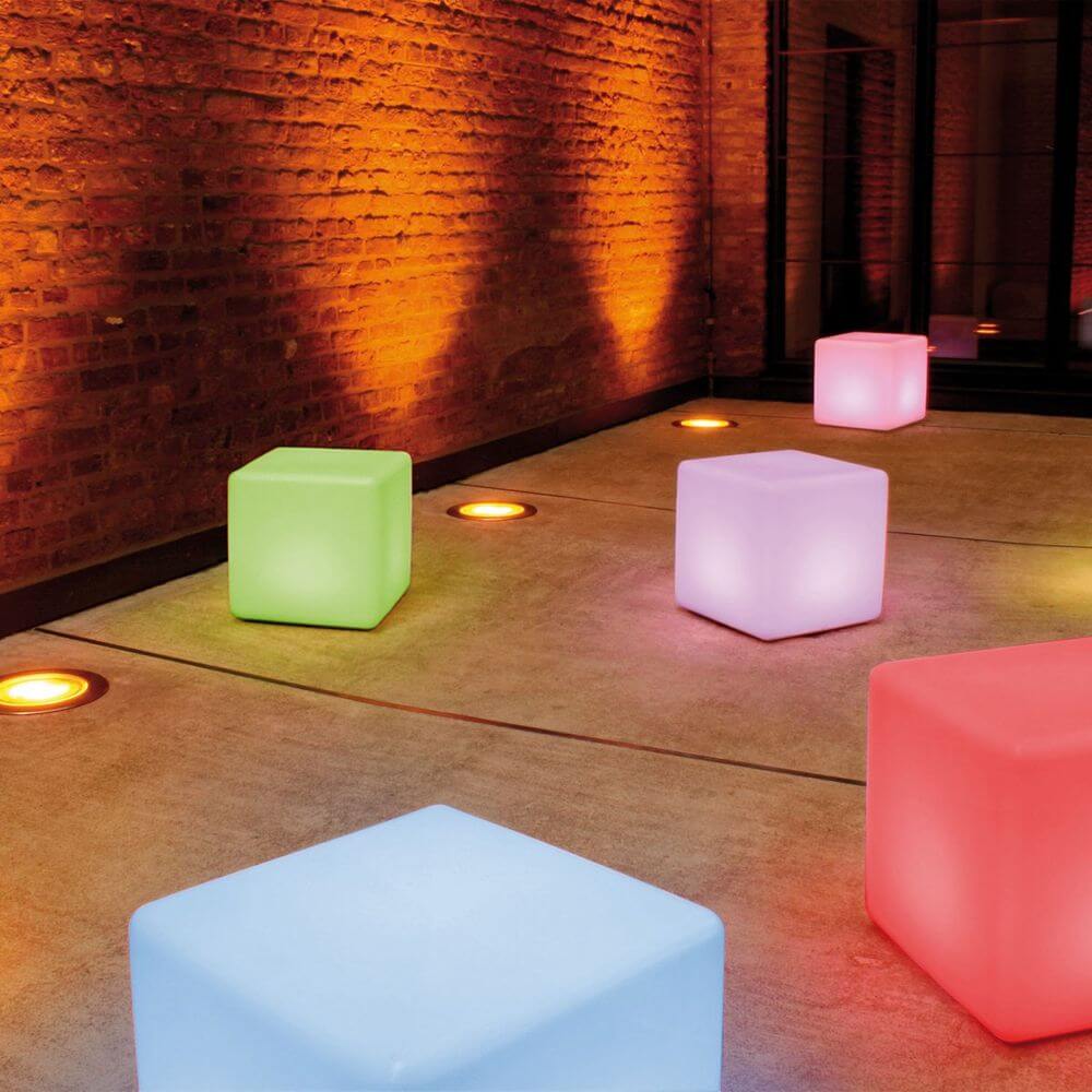 Moree Cube Outdoor LED Sitzwürfel in verschiedenen Farben auf einem modernen Außenbereich mit kreativer Beleuchtung.