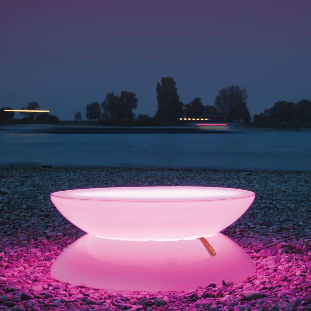 Moree Outdoor LED Tisch Lounge mit bunten LEDs bei Nacht am Wasser. Perfekt für den Außenbereich.
