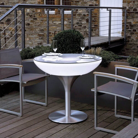 Stolik zewnętrzny Moree Lounge Table Outdoor 75 cm na tarasie ze stylowymi krzesłami i tacą.
