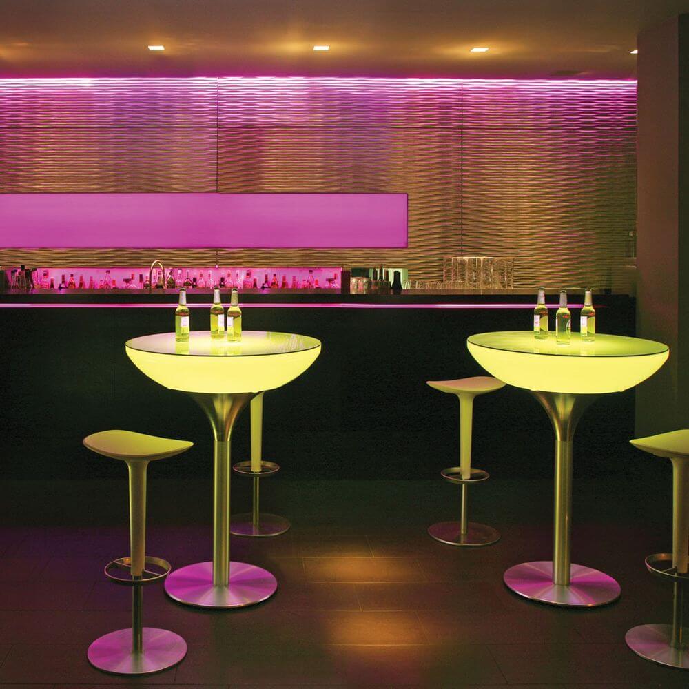 Moderne Lounge mit Moree LED Tischen, bunten Lichtern und stylischen Stühlen in trendiger Bar-Atmosphäre.