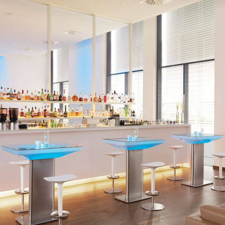 Moderne Bar mit beleuchteten Tischen und stilvollen Stühlen. Ideal für Events und Lounge-Ambiente.