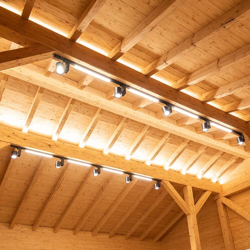 3-Phasen Linienleuchte 2200lm 20W 3000K warm Schwarz an Holzdecke montiert, gleichmäßige Raumausleuchtung.