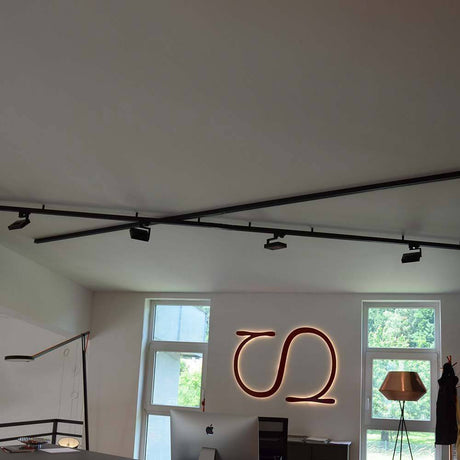 Moderne Bürobeleuchtung mit 3-Phasen-Linearschiene und eleganter Dekoration in einem hellen Raum.