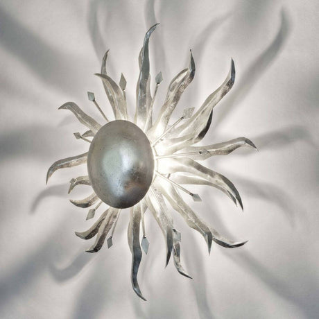 Aplique Sonne Piccola de hierro plateado con elegantes haces de luz y brillo metálico en diseño de sol.