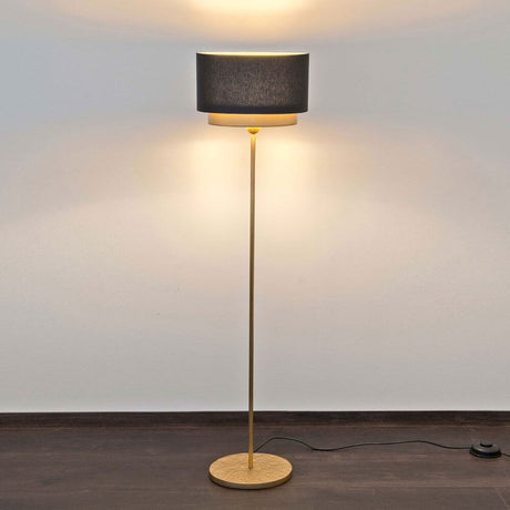 Floor lamp Mattia Oval Iron Gold-Black with elegant design on a dark floor.