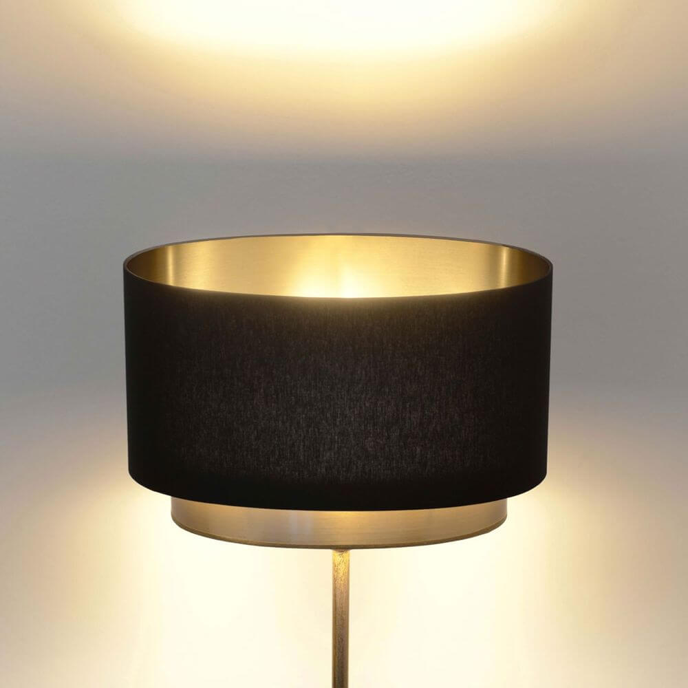 Golvlampa Mattia Oval Järn Guld-Svart med svart lampskärm och gyllene insida.
