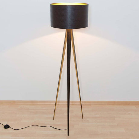 Candeeiro de pé Petra Ferro Castanho-Preto-Dourado sobre um pavimento de madeira clara com um design elegante.