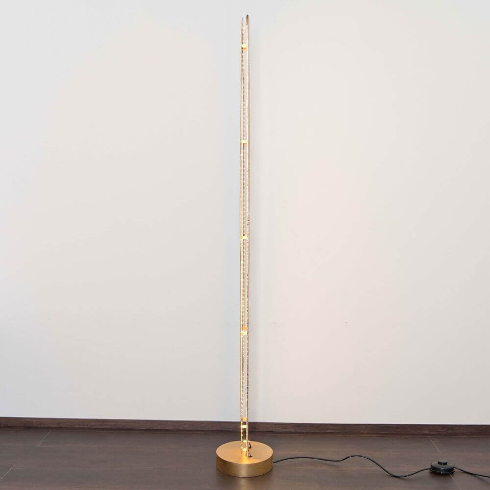 Stehleuchte Simbolo Eisen Braun-Schwarz-Gold in goldener Ausführung auf Holzfußboden.