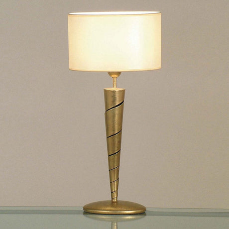 Table lamp Innovazione iron gold with an elegant conical shape and cream-colored lampshade.