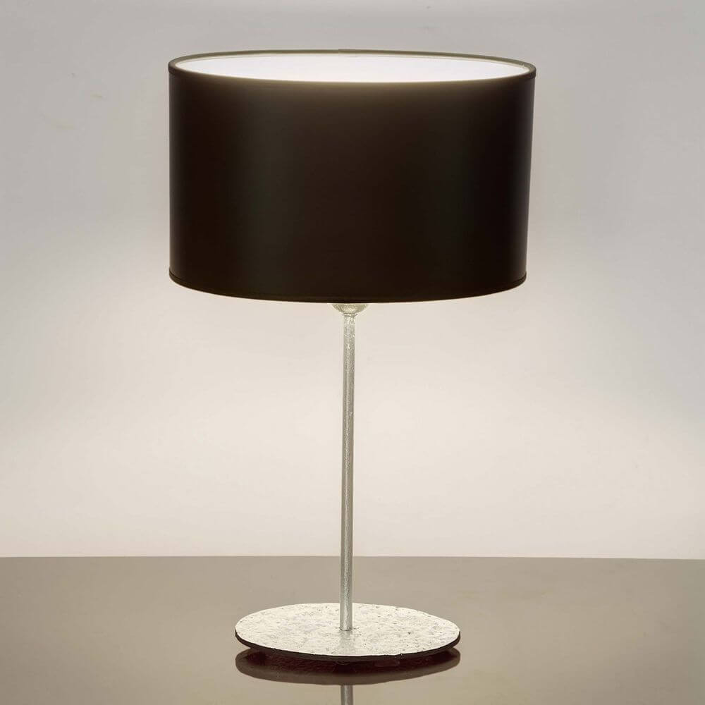 Tischleuchte Mattia Oval Eisen Silber-Schwarz auf einem Tisch, modernes Design mit schwarzem Lampenschirm.