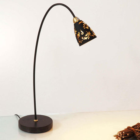 Table lamp Alice glass black, gold on a table with a curved lamp arm.