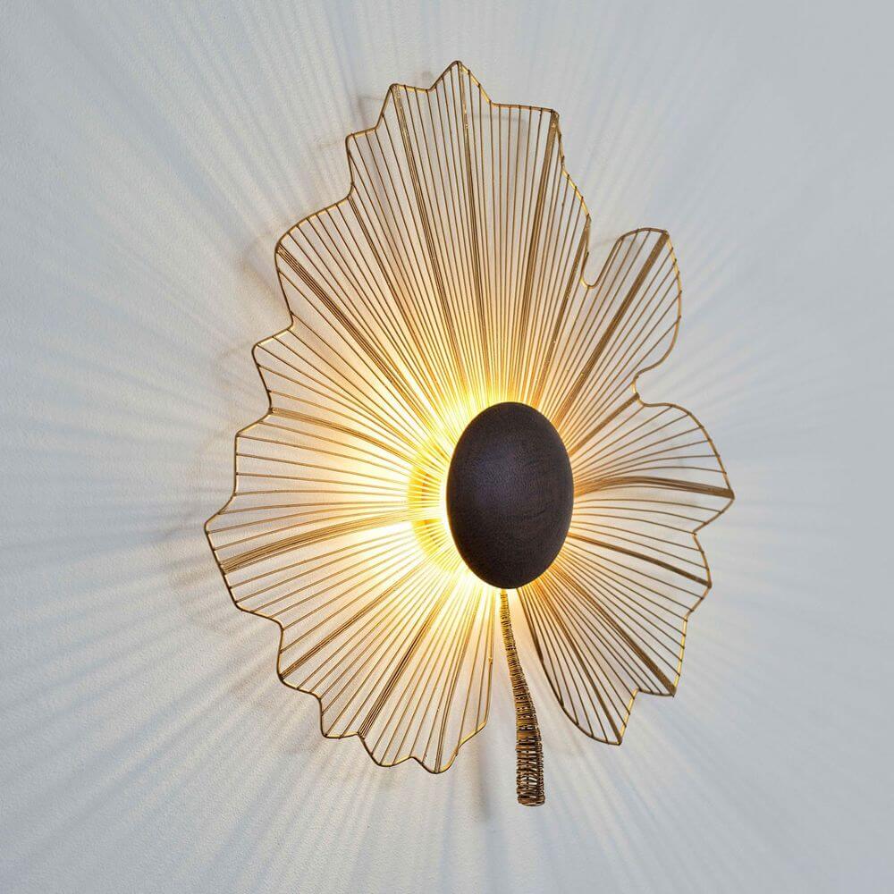 Wandleuchte Tremolo Klein Eisendraht Gold-Braun-Schwarz an einer Wand montiert, im blütenförmigen Design.