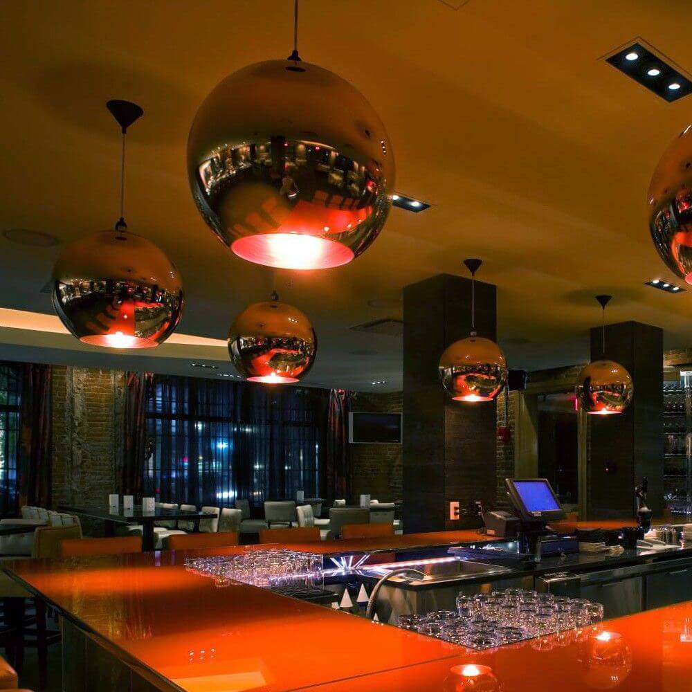 L Glaskugel Pendelleuchte Kupfer Ø 40cm in modernem Restaurant-Ambiente, stilvolle Beleuchtung auf Bar.