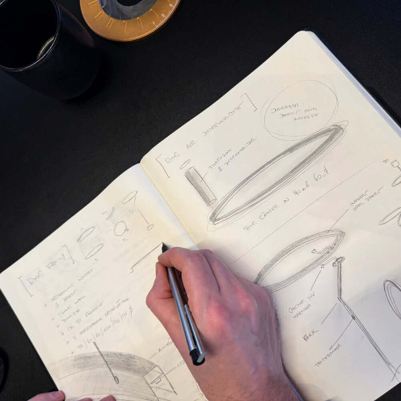 Hand skizziert Ideen in einem Notizbuch, um Designkonzepte zu entwickeln.