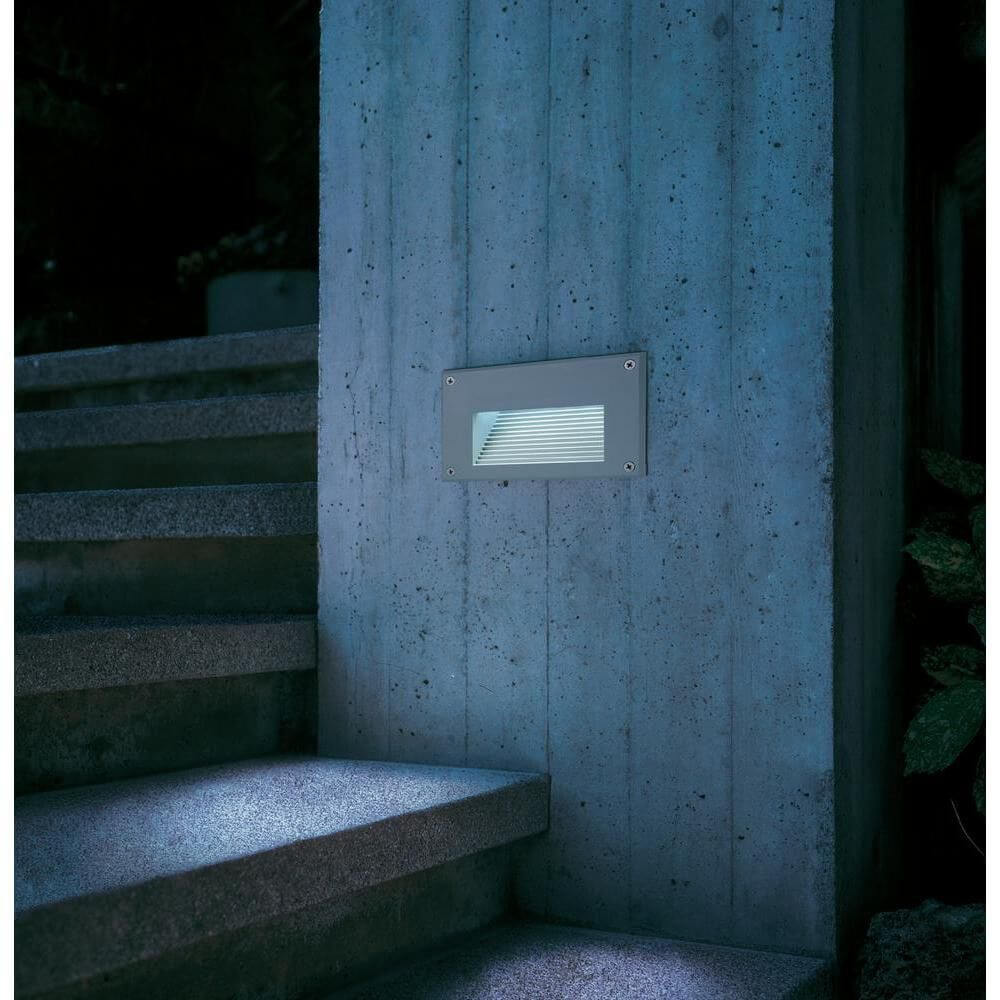 Brick LED Wandleuchte rechteckig in silbergrau, warmweißes Licht für Außenbereich, installiert an einer Betonwand.