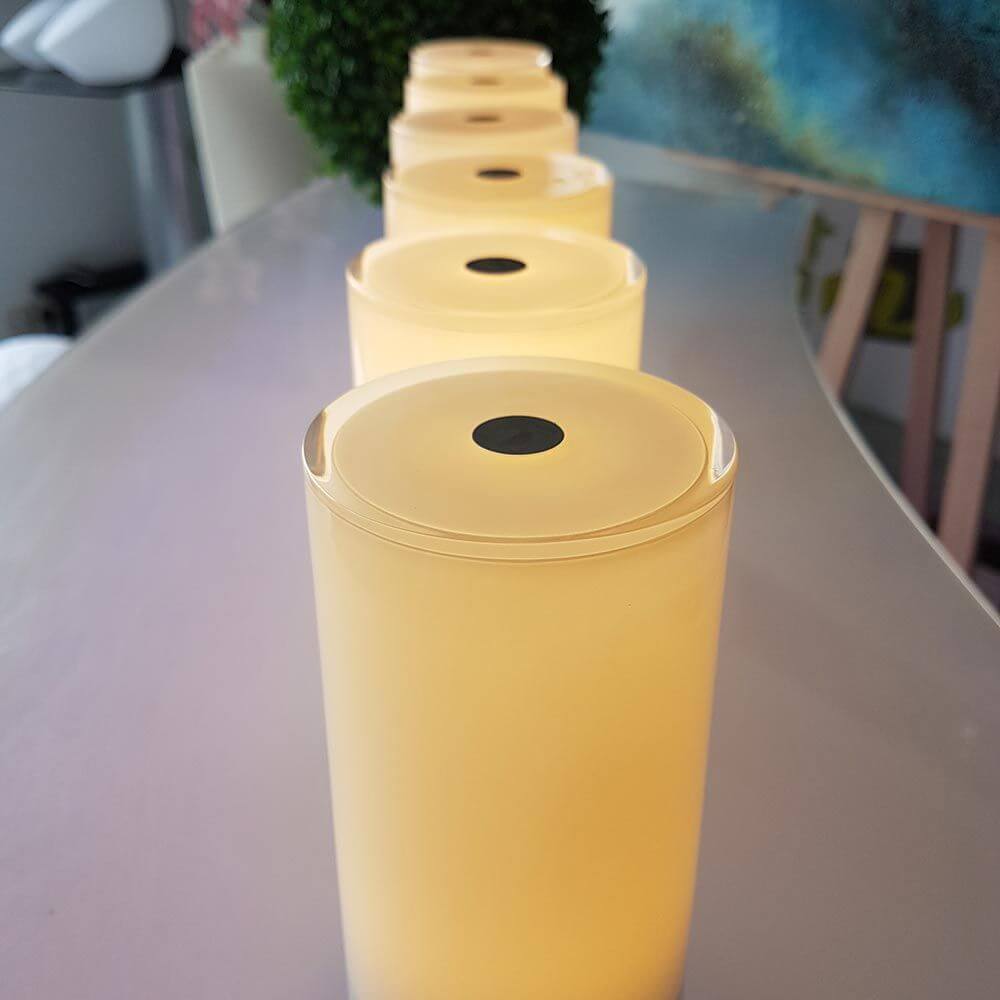 Reihe von 6 Akku-LED-Tischlampen in eleganter Glasoptik auf einem Tisch.