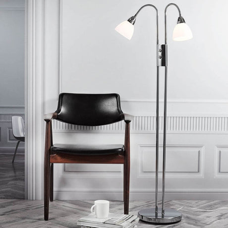 Candeeiro de pé Ray regulável Cromado, Transparente ao lado de uma cadeira preta num espaço moderno com luz suave.