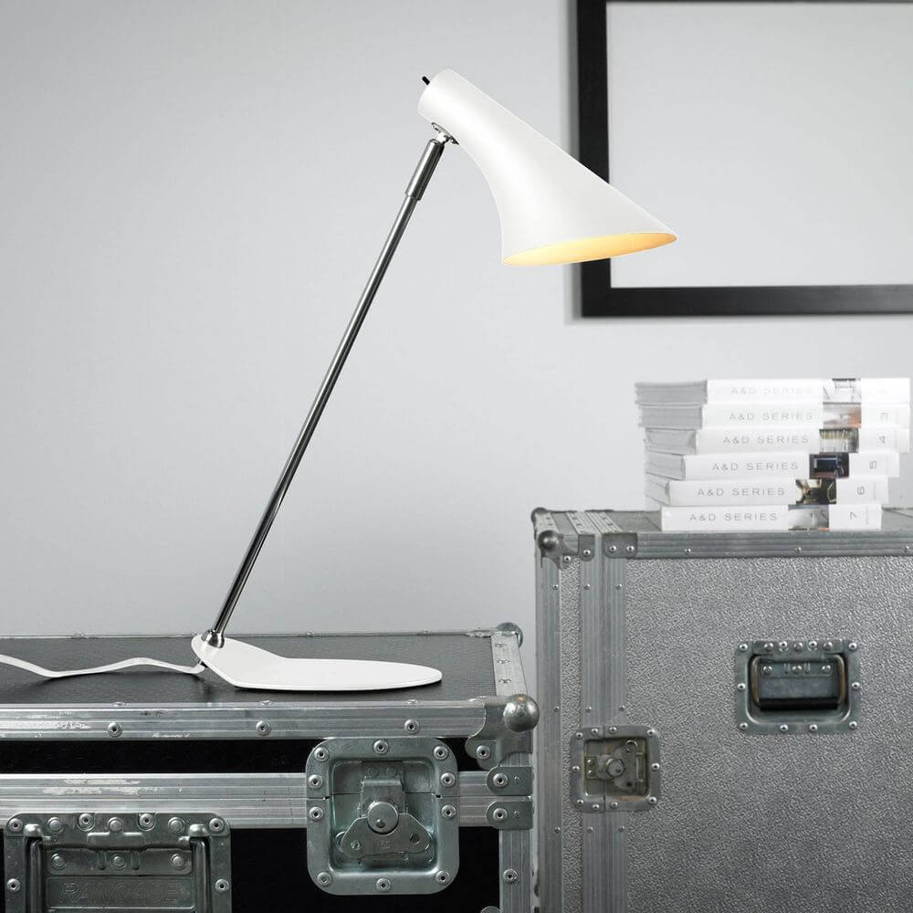 Lampada da tavolo Vanila bianca su un tavolo con valigie, adatta per un design d'arredo moderno e un'illuminazione elegante.